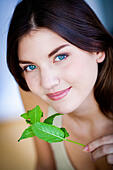 Woman smelling mint leaves (Mentha sp.) - Stock Image - E5R122 - E5R122