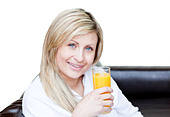 Smiling woman drinking an orange jus - Stock Image - BNW818 - BNW818